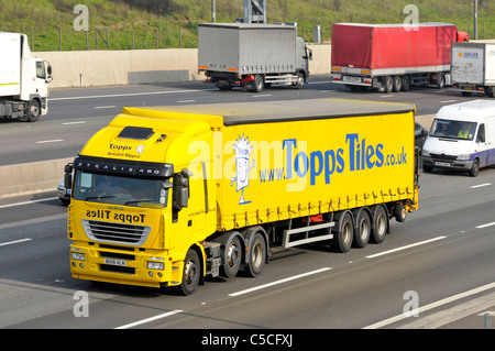 Vue de face jaune hgv magasin livraison camion Topps Tiles publicités web de marque sur la vue latérale remorque rideau d'accès rabattable sur la route d'autoroute du Royaume-Uni Banque D'Images