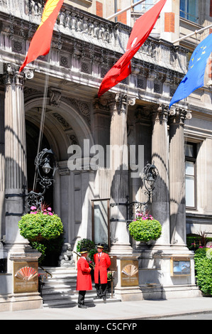 Drapeaux au-dessus de deux portiers en uniforme à la façade d'entrée Au luxueux hôtel cinq étoiles Mandarin Oriental Hyde Park À Londres Knightsbridge, Angleterre, Royaume-Uni Banque D'Images