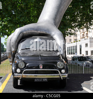 Scène de rue à Londres main sur voiture Fiat art moderne sculpture 'Vroom Vroom" par l'artiste italien Lorenzo Quinn milieu de Park Lane Mayfair Londres UK Banque D'Images