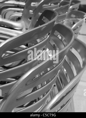 Close up of shiny metal stacked chaises de restaurant comme une image en noir et blanc Banque D'Images