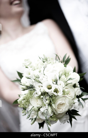 Close-up midsection of a bride holding a bouquet