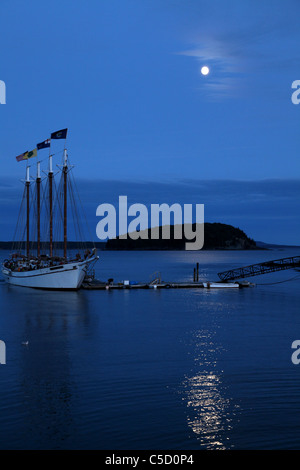 Voile bateau ancré dans un port à la pleine lune avec la lune reflétant de l'océan Banque D'Images