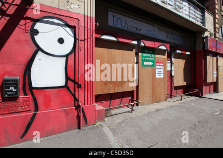 Stik figure peint sur un front Shop, Commercial Road London, UK. Banque D'Images