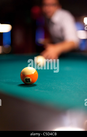 Jeune homme jouant 8 ball billard dans un bar Banque D'Images