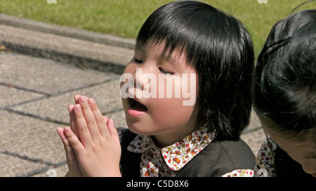 HONG KONG Maryknoll Convent School, Kowloontong, Kowloon. Fille priant. photo par Sean Sprague Banque D'Images