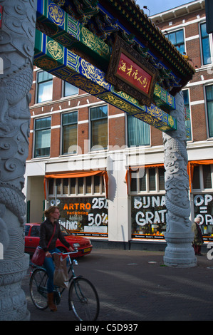 Les cyclistes passant par gate dans le Chinatown de La Haye Den Haag, dans la province de la Hollande-méridionale Pays-Bas Europe Banque D'Images