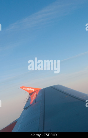 Vue à travers une fenêtre d'avion Easyjet volant au-dessus des nuages. Banque D'Images