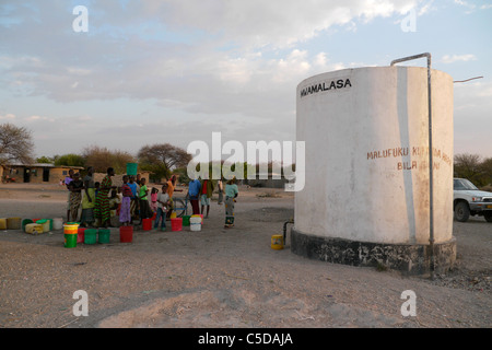 Tanzanie Village d'Mwamalasa, Shinyanga. La collecte de l'eau d'un réservoir de stockage. L'eau est pompée par les éoliennes dans le réservoir. Banque D'Images