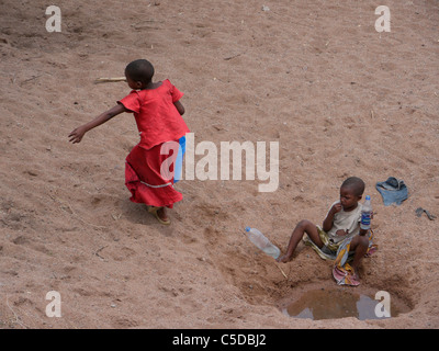 Les enfants faire la collecte de l'eau à partir d'un lit d'une rivière asséchée près de Shinyanga. photo par Sean Sprague Banque D'Images