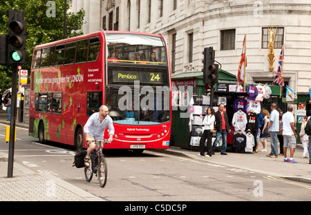 Un cycliste sur son vélo et un bus londonien en circulation sur le Strand, Central London, Royaume-Uni Banque D'Images