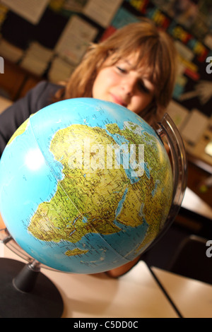 L'éducation scolaire à l'élève à la world globe en leçon de géographie Banque D'Images