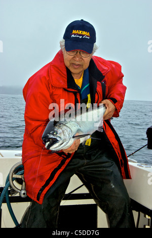 Asian male holding big sport pris le saumon quinnat Kyuquot Sound BC Banque D'Images