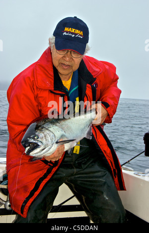 Asian male holding big sport pris le saumon quinnat Kyuquot Sound BC Banque D'Images