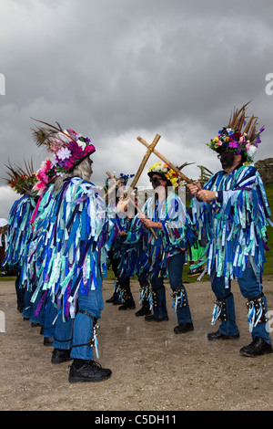 Danseuses Exmoor Border Morris, à fond noir, portant de longs chiffons déchirés, des vêtements en matériaux bleus et blancs, des vêtements et des danses, des événements en plein air, danseur de rue, danseurs costumés, des chiffons longs, des cloggies, spectacle, représentation de musiciens folkloriques, musiciens multicolores, populaire, Spectacle de divertissement traditionnel au Tutbury Castle Weekend of Dance Derbyshire, Royaume-Uni. Banque D'Images