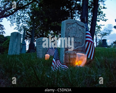 Des sépultures de guerre civile sont éclairées avec des bougies pour commémorer le Jour du Souvenir au Cimetière Vert-bois à Brooklyn, New York. Banque D'Images