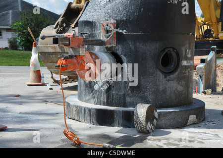 Le forage d'un noyau en béton de trou d'santary pour une nouvelle ligne de service. Banque D'Images