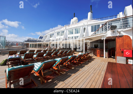 Les passagers à bronzer près de la piscine sur le Queen Mary 2 de Cunard paquebot. Banque D'Images