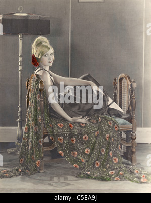 Smiling woman sitting on divan Banque D'Images