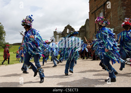 Danseuses Exmoor Border Morris, à fond noir, portant de longs chiffons déchirés, des vêtements en matériaux bleus et blancs, des vêtements et des danses, des événements en plein air, danseur de rue, danseurs costumés, des chiffons longs, des cloggies, spectacle, représentation de musiciens folkloriques, musiciens multicolores, populaire, Spectacle de divertissement traditionnel au Tutbury Castle Weekend of Dance Derbyshire, Royaume-Uni. Banque D'Images