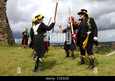 Powderkegs Morris, danseurs et amuseurs publics, de détails et de personnes, effectuant à Tutbury Castle Week-end du Derbyshire UK Danse. Un groupe mixte d'hommes et de femmes qui la danse traditionnelle et l'évolution des Border Morris. On croit que les danseurs frontière déguisement remonte à l'époque de 'travailleurs' (la maison est liée à l'emploi) lorsque pendant fois argent pourrait être faite dans les foires de danser et jouer de la musique. Les travailleurs seraient expulsées si pris par le Squire donc ils ont utilisé le matériel à portée de main - chiffons et de poussière de charbon de se déguiser. Banque D'Images