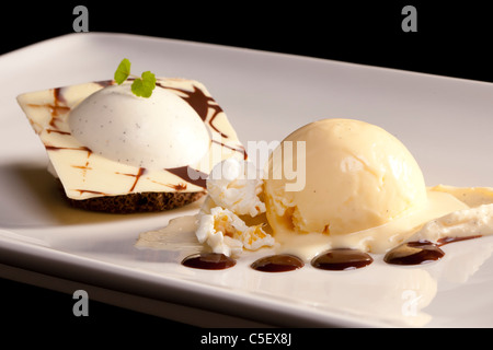 Alternative à un dessert classique Dame Blanche : glace vanille avec sauce chaude chocalate et crème fouettée sucrée Banque D'Images