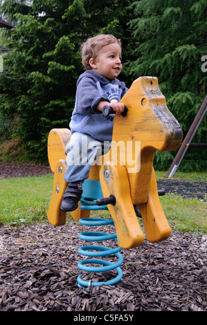 Jeune enfant de deux pièces sur un cheval de bois photographié en Autriche Banque D'Images