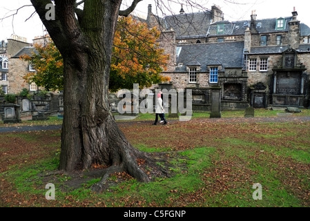 Un jeune couple walking cours des pierres tombales et des maisons n Greyfriars Kirkyard cimetière en automne Edimbourg Ecosse KATHY DEWITT Banque D'Images