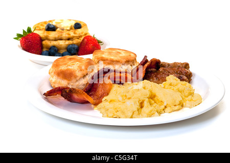 Oeufs brouillés, bacon, saucisse lien, biscuits, gaufres et avec des fraises et des bleuets. Isolé sur fond blanc. Banque D'Images