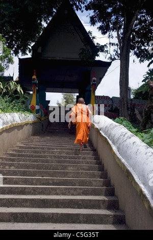 Un moine bouddhiste est l'ascension d'une longue et raide escalier menant à un beau temple bouddhiste dans le Nord de la Thaïlande. Banque D'Images