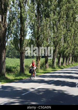 Une femme d'âge moyen parcourt la campagne picarde français près de Albert sur un vélo pliant Brompton Banque D'Images