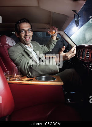 Bel homme de boire dans la voiture Banque D'Images