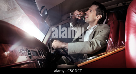 Bel homme de boire dans la voiture Banque D'Images