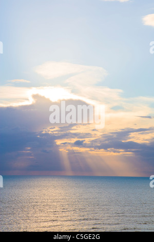 Des faisceaux de lumière du soleil à travers les nuages pause sur la mer Banque D'Images