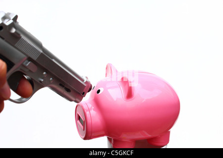 Un pistolet d'argent est dirigé vers un pink piggy bank. Banque D'Images