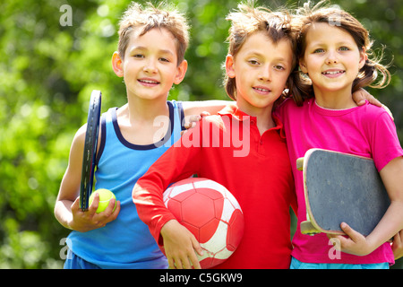 Faire place au portrait de trois enfants avec des équipements sportifs Banque D'Images