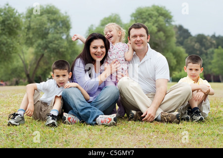 Portrait de famille heureuse de cinq sur la terre verte sur fond naturel Banque D'Images