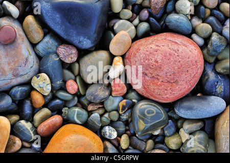 L'eau colorée cailloux lissés en surf à plage de galets Banque D'Images