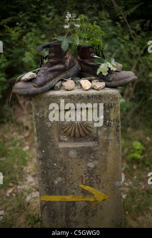 Vieilles bottes remplies de fleurs et plantes placé sur une borne dans le chemin de Saint-Jacques de Compostelle, Santiago de Compostela, Banque D'Images