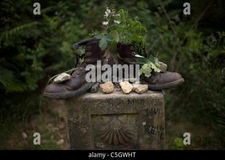 Vieilles bottes remplies de fleurs et plantes placé sur une borne dans le chemin de Saint-Jacques de Compostelle, Santiago de Compostela, Banque D'Images