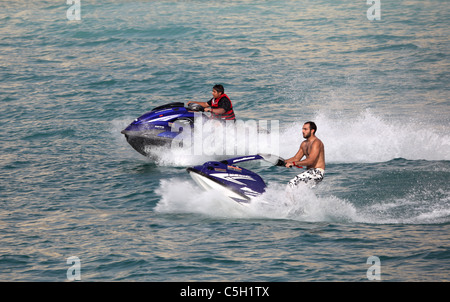 Les jeunes hommes arabes having fun riding scooter à Dubaï, Émirats Arabes Unis Banque D'Images