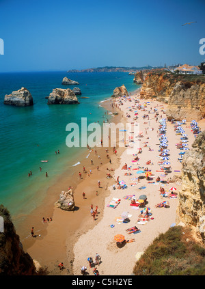 Des parasols, des piles de la mer et le soleil sur les plages de la Méditerranée le long de la plage Praia da Rocha au Portugal Banque D'Images