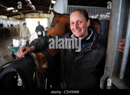 Une femme jockey avec un cheval à la stabilité dans le Gloucestershire UK Banque D'Images