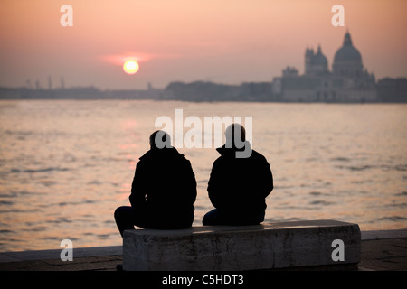 Deux hommes regardant le coucher de soleil sur Santa Maria della Salute, Venise, Italie Banque D'Images