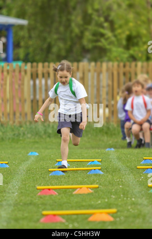 Jeune fille en compétition dans l'exécution de course sur sportsday Banque D'Images