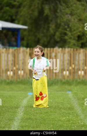 Jeune fille en compétition dans un sac course sur sportsday Banque D'Images