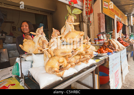 Femme vend à l'extérieur du poulet, un typique marché CDM, trépidant marché bondé qui vendent de tout, des aliments aux vêtements à Hanoi Banque D'Images