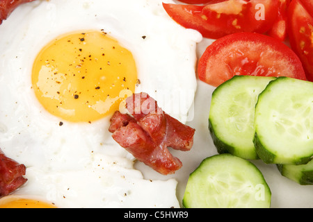 Close-up d'oeufs au plat avec des saucisses et légumes Banque D'Images