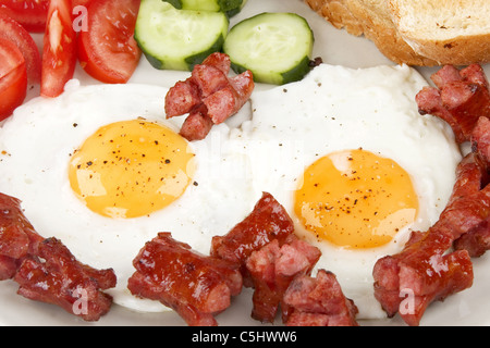 Close-up d'oeufs au plat avec des saucisses et légumes Banque D'Images