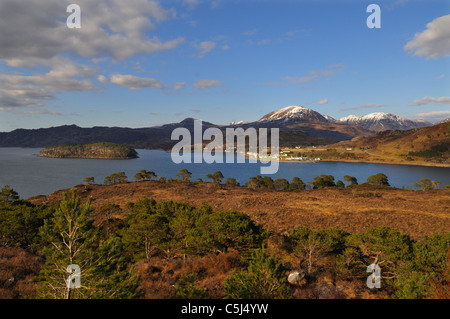 Au loin les sommets enneigés de l'élever au-delà de Torridon Loch Torridon et à proximité des bois de pins et le village de Shieldaig, Wester Banque D'Images