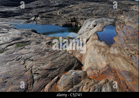 Des formations rocheuses sculptées par les glaces et les piscines d'eau de fonte du glacier Svartisen ci-dessous, Svartisdalen, la Norvège. Banque D'Images